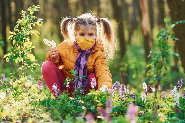 Szczęśliwa Mała Dziewczynka Masce Ochronnej Siedzi Wiosennym Lesie Dzień — Zdjęcie stockowe