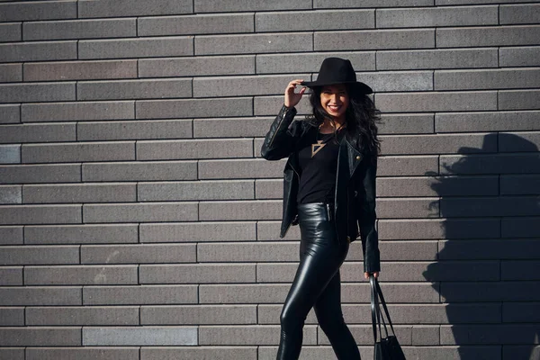 Beautiful Brunette Curly Hair Black Clothes Holding Bag Outdoors Wall — Stockfoto