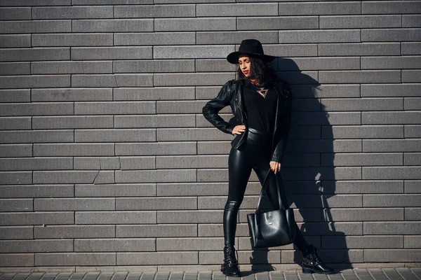 Beautiful Brunette Curly Hair Black Clothes Holding Bag Outdoors Wall — 스톡 사진