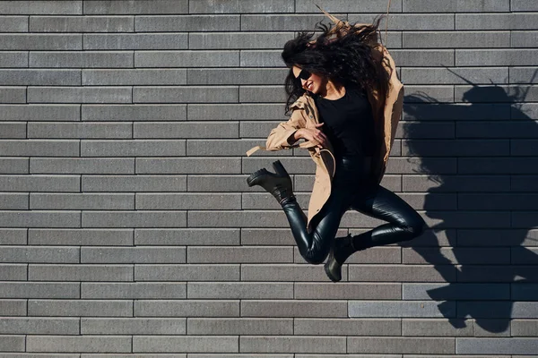Красивая Брюнетка Вьющимися Волосами Черной Одежде Прыгает Веселится Открытом Воздухе — стоковое фото