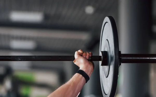 stock image Lifting barbell. Young sportive strong man in black wear have workout day in gym.