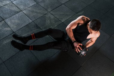 Siyah giysili genç sporcu adam spor salonunda top oynuyor..