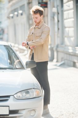 Arabasına doğru yürüdü. Şehrin dışında şık kıyafetler içinde zarif bir genç adam..