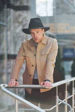 Siyah şapkalı zarif genç adam ve resmi klas giysiler şehrin dışında..