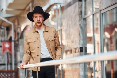 Siyah şapkalı zarif genç adam ve resmi klas giysiler şehrin dışında..