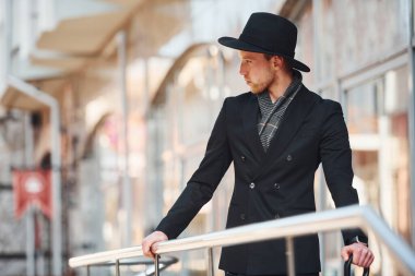 Siyah şapkalı, açık havada şemsiyesi olan zarif bir genç..