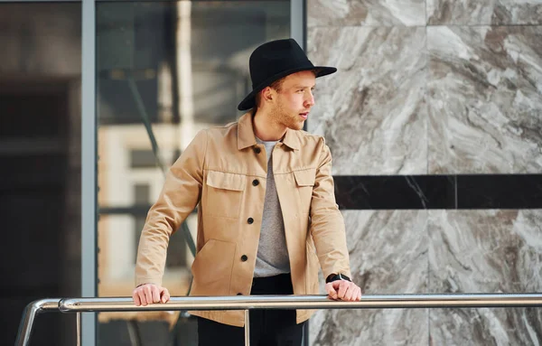 Siyah şapkalı zarif genç adam ve resmi klas giysiler şehrin dışında..