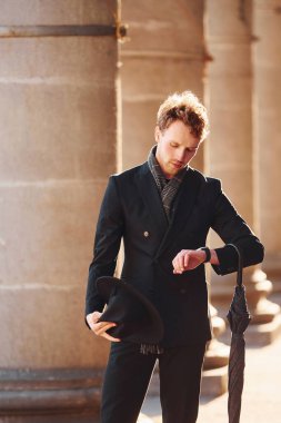 Şehrin dışında şık kıyafetler içinde zarif bir genç adam..