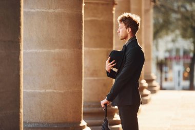 Siyah şapkalı, elinde şemsiyesi olan şık bir genç adam..