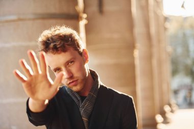 El hareketini durdurur. Şehrin dışında şık kıyafetler içinde zarif bir genç adam..