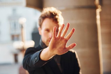 El hareketini durdurur. Şehrin dışında şık kıyafetler içinde zarif bir genç adam..