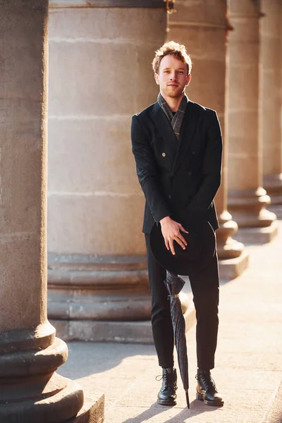 Şehrin dışında şık kıyafetler içinde zarif bir genç adam..