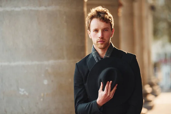 Portrait of elegant young man in formal classy clothes that outdoors in the city.