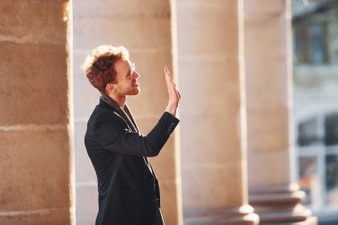 Biriyle konuşuyorum. Şehrin dışında şık kıyafetler içinde zarif bir genç adam..