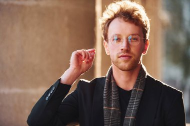 Şehirde gözlüklü zarif bir genç adam portresi ve resmi klas kıyafetler..