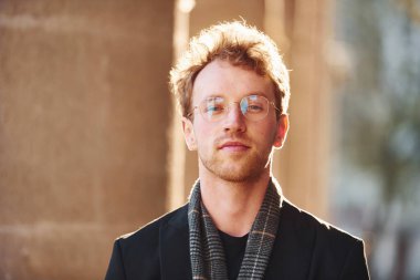 Şehirde gözlüklü zarif bir genç adam portresi ve resmi klas kıyafetler..