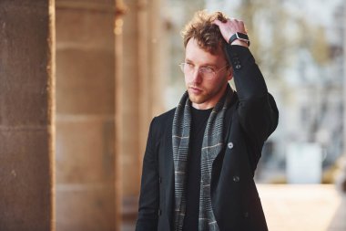 Şehrin dışında şık kıyafetler içinde zarif bir genç adam..