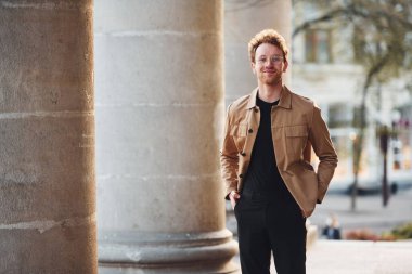 Şehrin dışında şık kıyafetler içinde zarif bir genç adam..