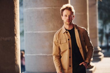 Şehrin dışında şık kıyafetler içinde zarif bir genç adam..