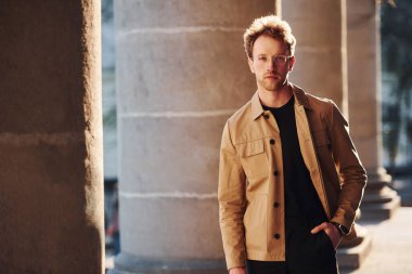 Şehrin dışında şık kıyafetler içinde zarif bir genç adam..