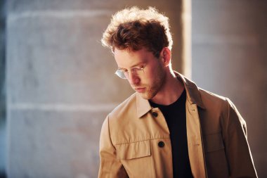 Şehrin dışında şık kıyafetler içinde zarif bir genç adam..