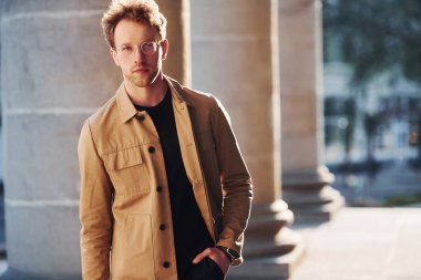 Şehrin dışında şık kıyafetler içinde zarif bir genç adam..