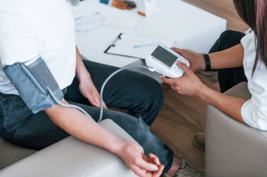 Kan basıncını ölçüyorum. Genç bayan, modern klinikteki kadın doktoru ziyaret ediyor..