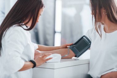 Kan basıncını ölçüyorum. Genç bayan, modern klinikteki kadın doktoru ziyaret ediyor..