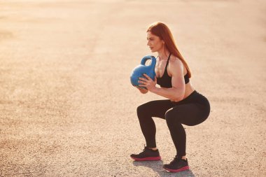 Ağırlık kaldırmak. Spor giyinen kadınların akşam vakti spor salonunda spor günleri olur..