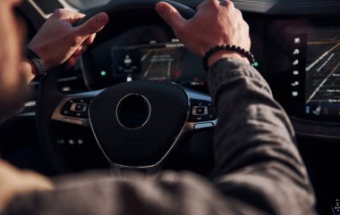 Arabasına binen şık giyinmiş, tıraşsız, yakışıklı adamın arka manzarası..