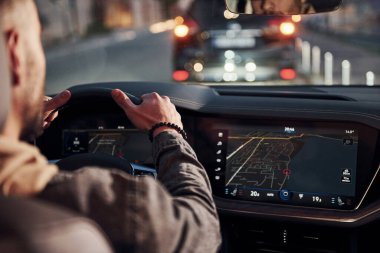 Arabasına binen şık giyinmiş, tıraşsız, yakışıklı adamın arka manzarası..