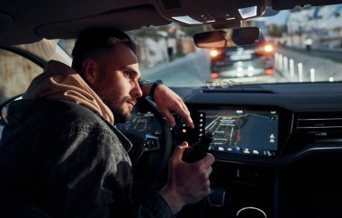 İçkili araba kullanma. Arabasının içinde şık giyinmiş, tıraşsız, yakışıklı bir adam..