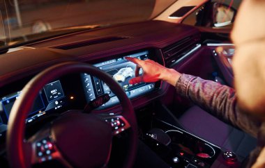 Navigasyon ekranı kullanılıyor. Şık giyinmiş, traşsız yakışıklı bir adam otomobiline biniyor..