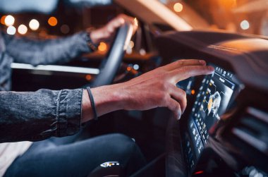 Navigasyon ekranı kullanılıyor. Şık giyinmiş, traşsız yakışıklı bir adam otomobiline biniyor..