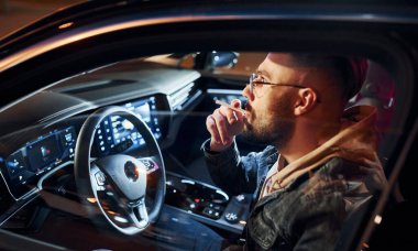 Sigara içiyorum. Şık giyinmiş, traşsız yakışıklı bir adam otomobiline biniyor..