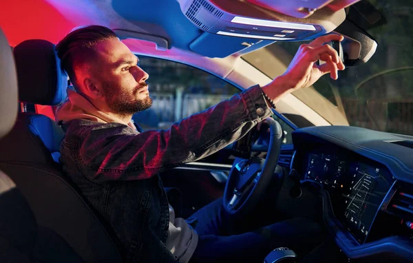 Siyah ve kırmızı polis ışıkları. İçkili araba kullanma. Arabasının içinde şık giyinmiş, tıraşsız yakışıklı bir adam..