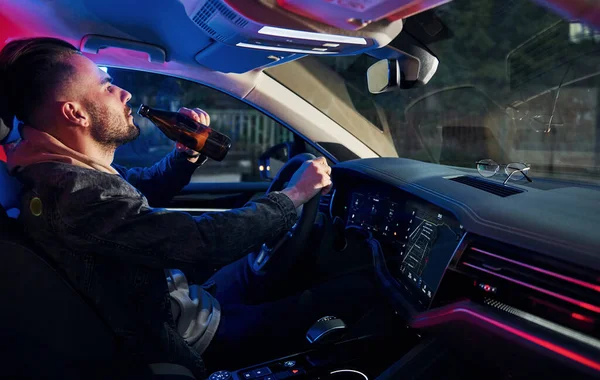 Siyah ve kırmızı polis ışıkları. İçkili araba kullanma. Arabasının içinde şık giyinmiş, tıraşsız yakışıklı bir adam..