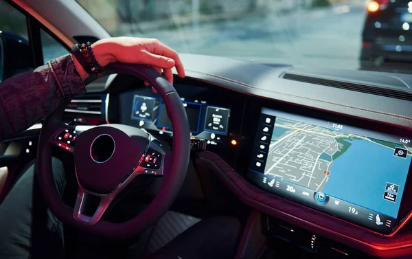 Şık giyinmiş, traşsız yakışıklı bir adam otomobiline biniyor..