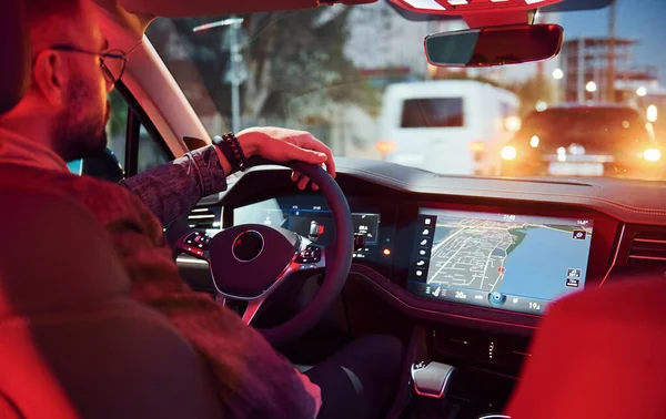 Şık giyinmiş, traşsız yakışıklı bir adam otomobiline biniyor..