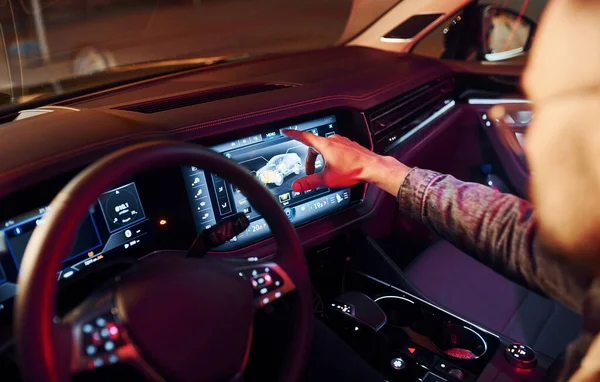 Navigasyon ekranı kullanılıyor. Şık giyinmiş, traşsız yakışıklı bir adam otomobiline biniyor..