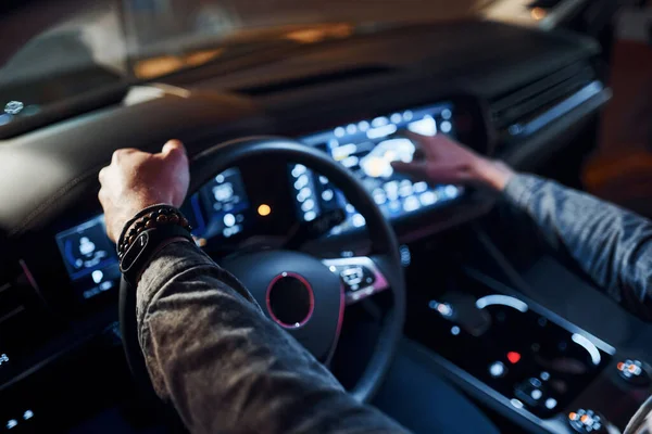 Navigasyon ekranı kullanılıyor. Şık giyinmiş, traşsız yakışıklı bir adam otomobiline biniyor..