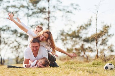Otururken ve yerde yatarken. Mutlu aile hafta sonları ormanda birlikte geçirir. Kızı ve oğluyla..