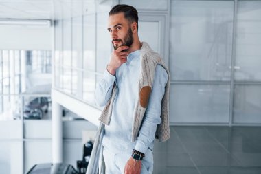 Gündüz vakti ofiste resmi kıyafetler içinde genç yakışıklı bir adam..