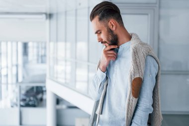 Gündüz vakti ofiste resmi kıyafetler içinde genç yakışıklı bir adam..