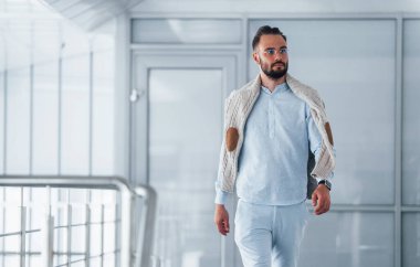 Gündüz vakti ofiste resmi kıyafetler içinde genç yakışıklı bir adam..