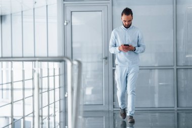 Gündüz vakti ofiste resmi kıyafetler içinde genç yakışıklı bir adam..