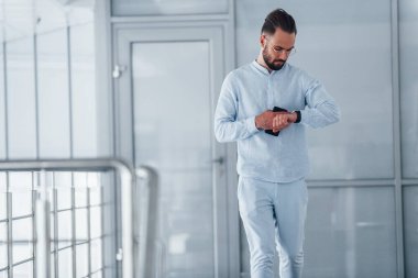 Gündüz vakti ofiste resmi kıyafetler içinde genç yakışıklı bir adam..