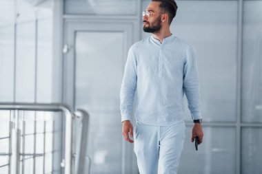 Gündüz vakti ofiste resmi kıyafetler içinde genç yakışıklı bir adam..