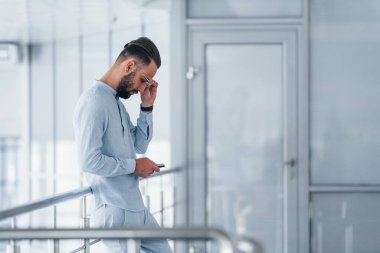 Telefonla. Gündüz vakti ofiste resmi kıyafetler içinde genç yakışıklı bir adam..