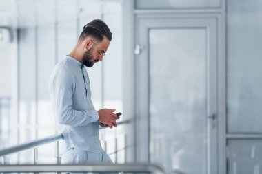 Telefonla. Gündüz vakti ofiste resmi kıyafetler içinde genç yakışıklı bir adam..